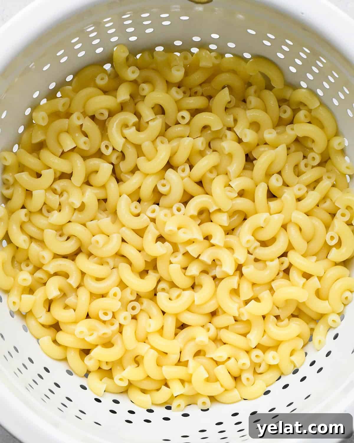 pasta draining in a colander to make veggie mac and cheese