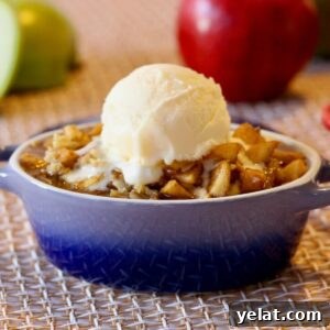 Apple and Pear Crumble with a scoop of vanilla ice cream on top.