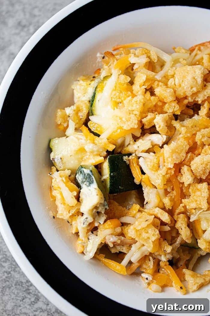 Zucchini Mini Pizzas: Bite-Sized Low-Carb Pizza Bites 9 overhead view of serving of healthy keto low carb chicken and zucchini casserole in a white bowl with a black stripped rim