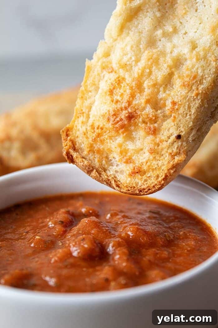 Zucchini Mini Pizzas: Bite-Sized Low-Carb Pizza Bites 12 sideview of easiest low carb garlic bread being dipped into white bowl with marinara dipping sauce