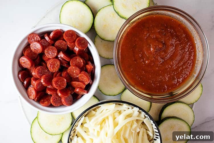 Zucchini Mini Pizzas: Bite-Sized Low-Carb Pizza Bites 3 overhead view of ingredients to make zucchini pizza bites including three bowls filled with sauce, mini pepperoni, shredded mozzarella, and sliced into circles zucchini