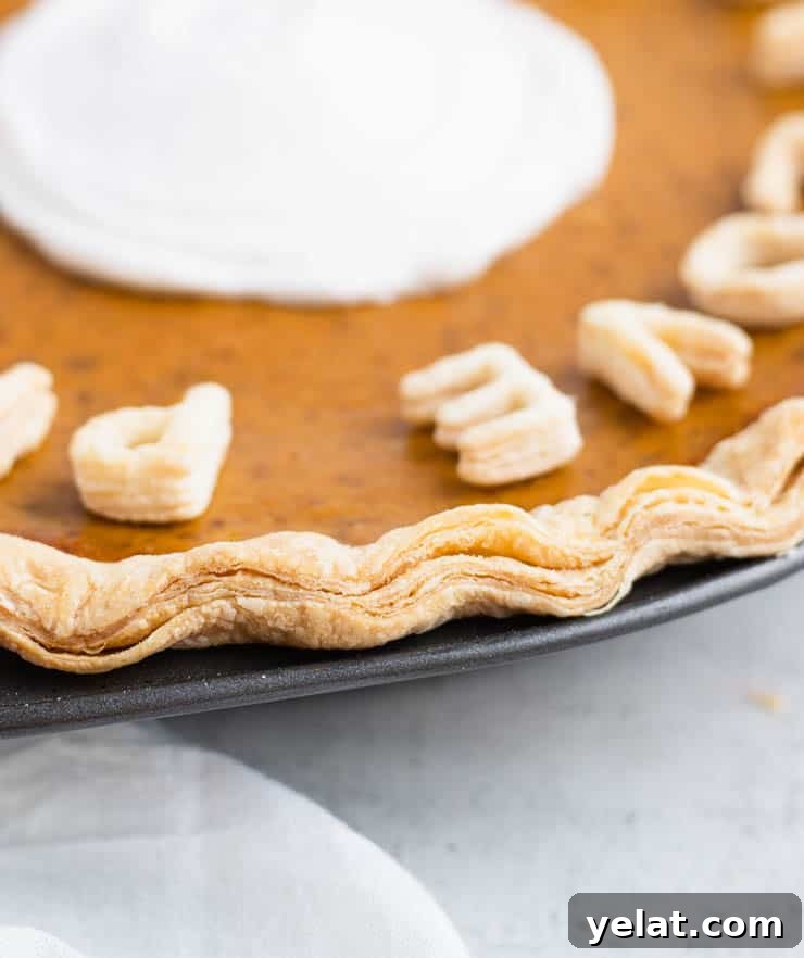Flaky Pie Crust Recipe: A Complete Step-by-Step Guide 8 Close up of the crimped edge of the crust of a pumpkin pie to show the layers of the crust.