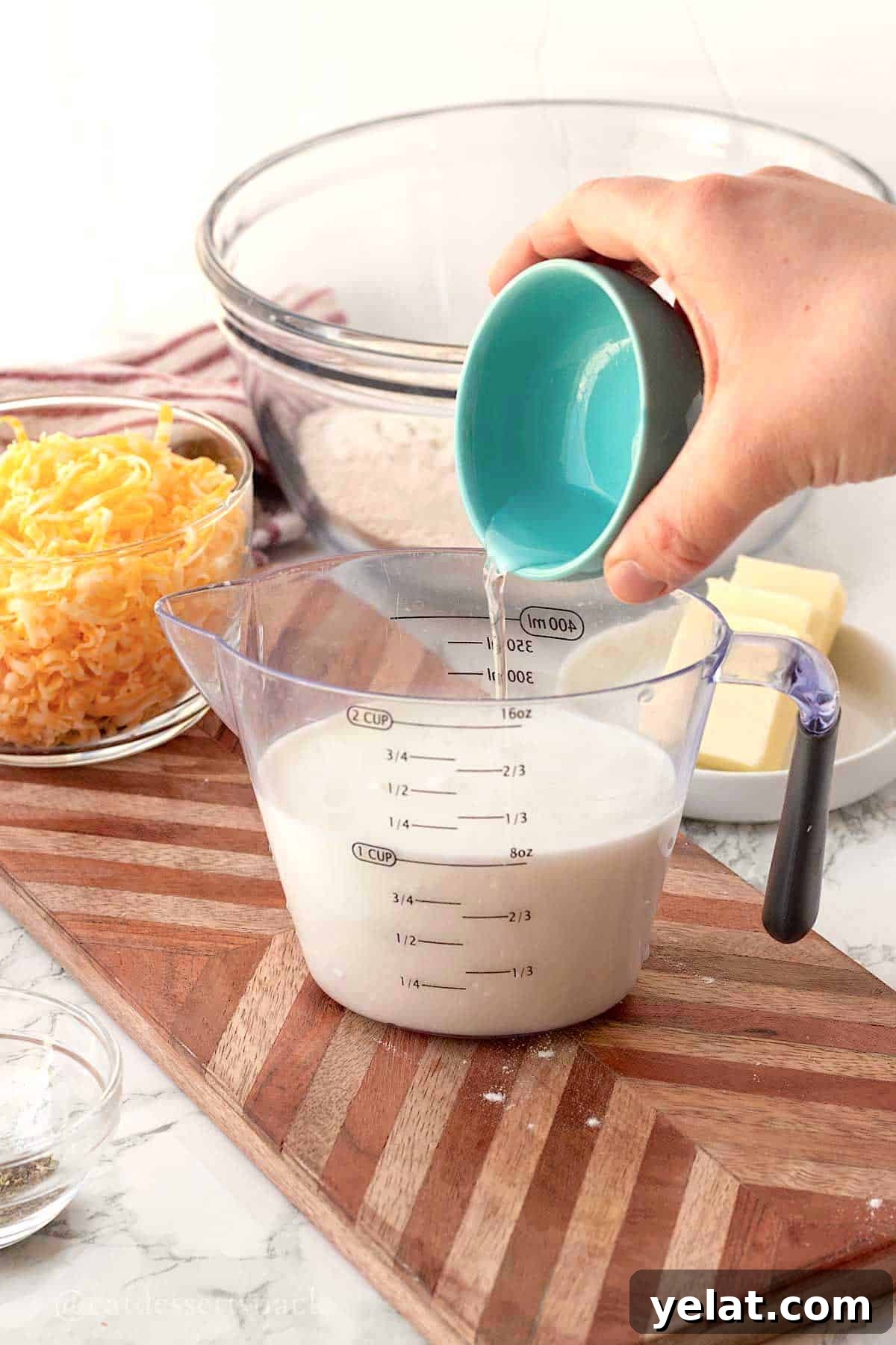Garlic Cheddar Drop Biscuits Recipe: Quick Savory Biscuits 4 Pouring vinegar into measuring cup of milk.
