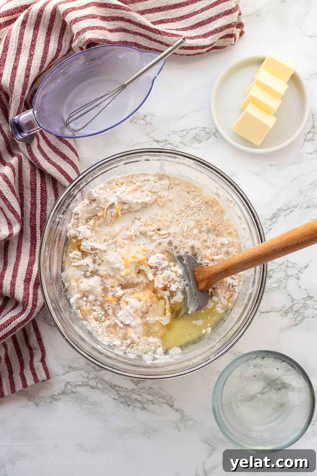 Garlic Cheddar Drop Biscuits Recipe: Quick Savory Biscuits 7 Wet and dry ingredients for biscuits in glass bowl with spatula.