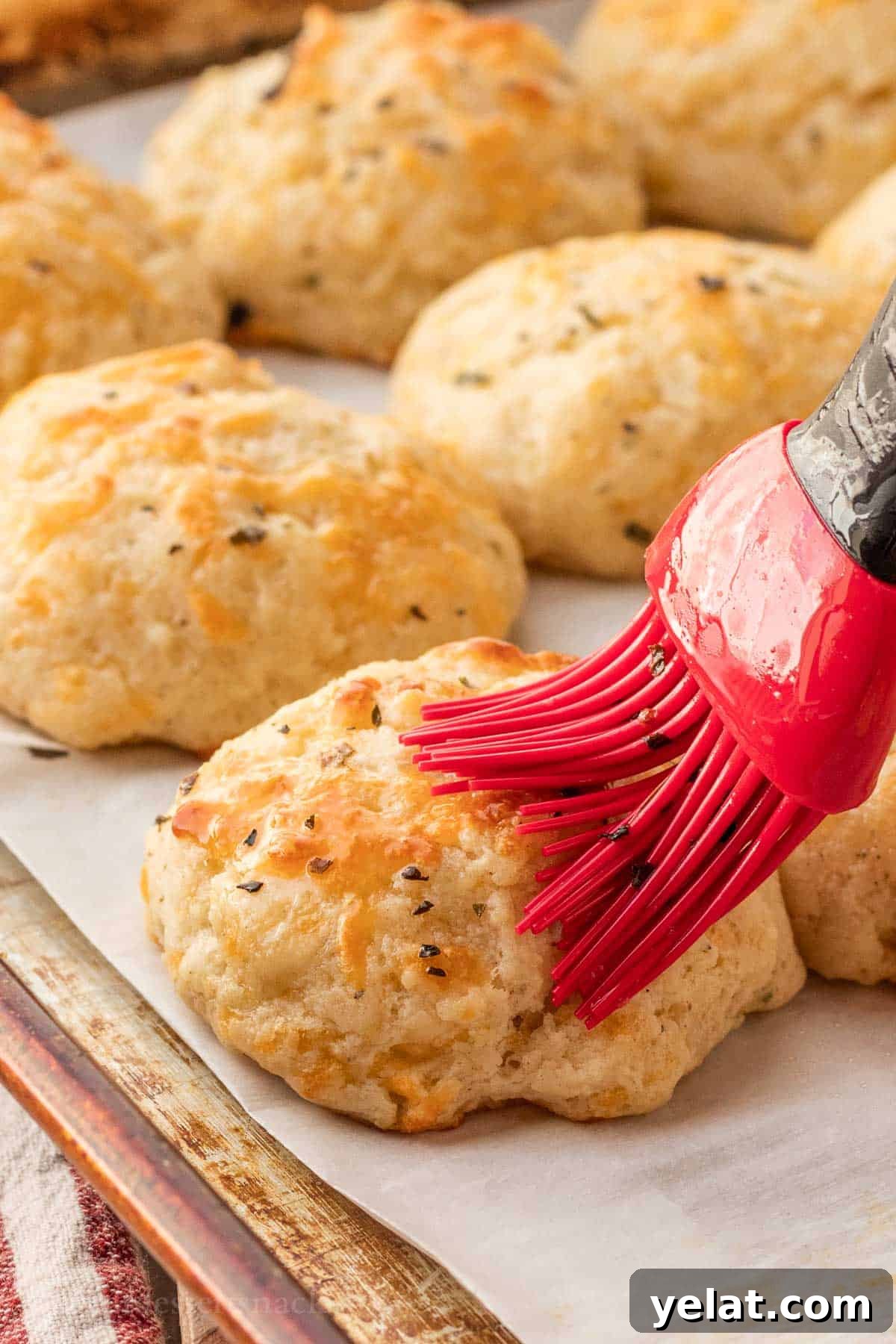 Garlic Cheddar Drop Biscuits Recipe: Quick Savory Biscuits 9 Red brush with butter on baked cheddar drop biscuit.