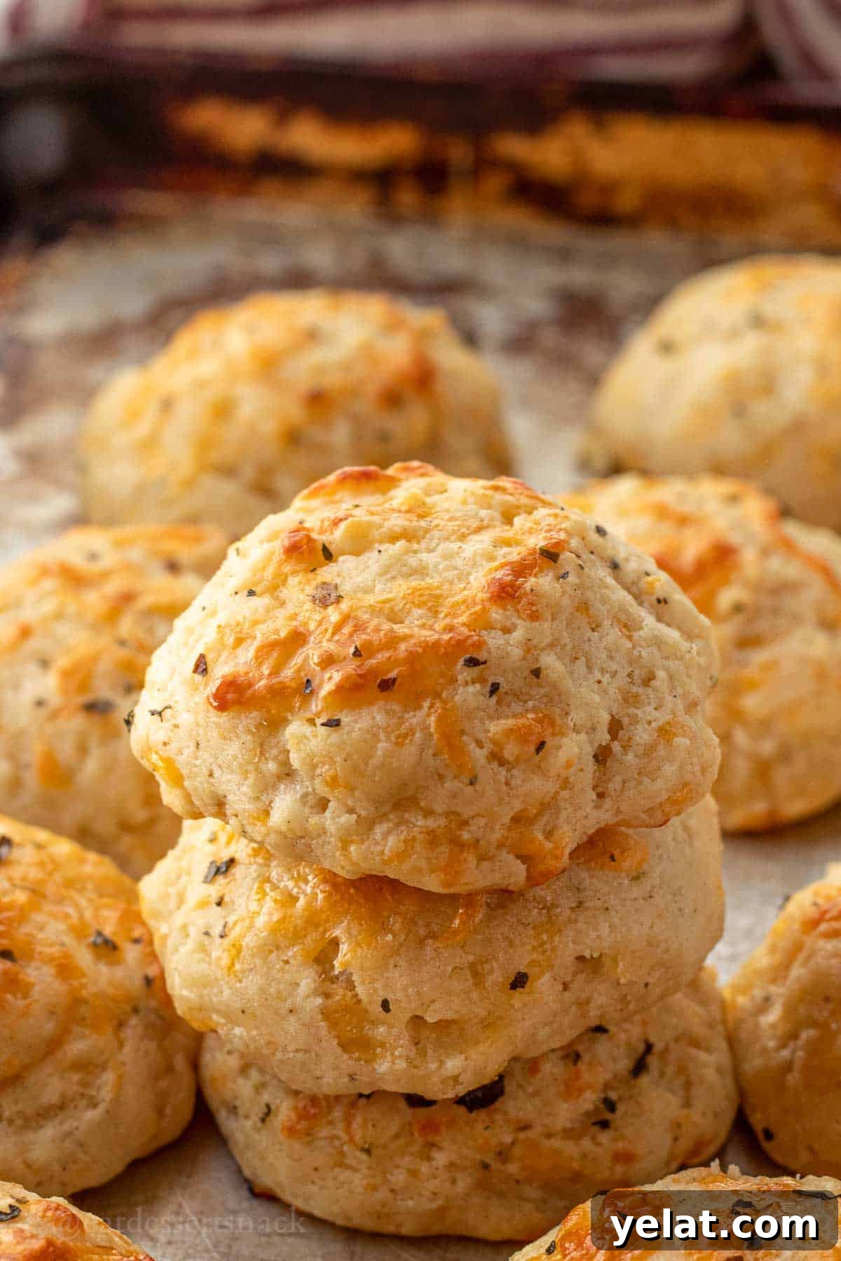 Garlic Cheddar Drop Biscuits Recipe: Quick Savory Biscuits 10 Stack of baked cheddar garlic drop biscuits on metal pan.
