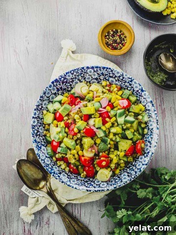 bird's eye view of a blue flowered plate filled with avocado corn salad