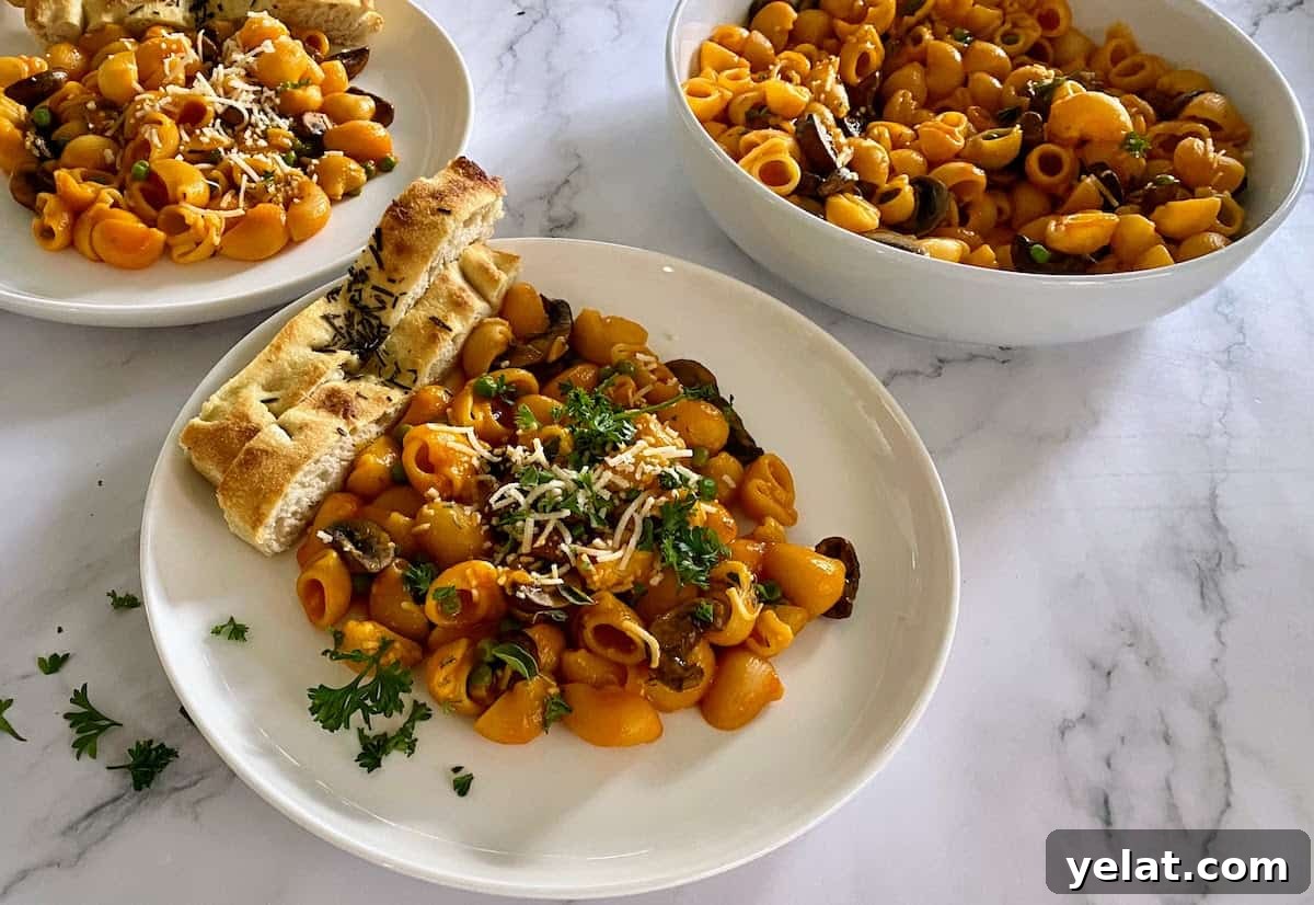 Creamy Roasted Red Pepper Pasta with Parmesan and Basil 12 red pepper pasta on two plates, and a bowl of pasta on the table.