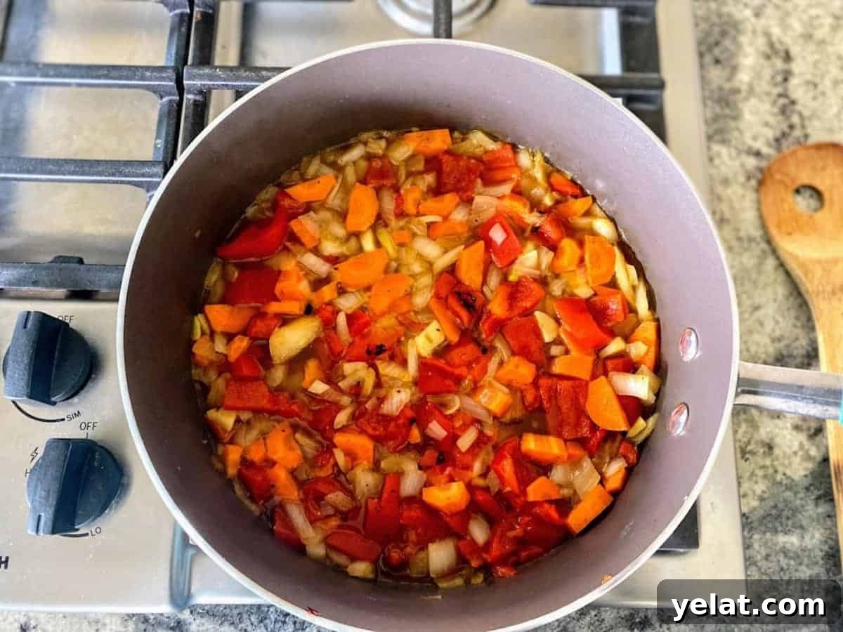Creamy Roasted Red Pepper Pasta with Parmesan and Basil 7 Red pepper pasta recipe ingredients in a pot cooking on the stove.