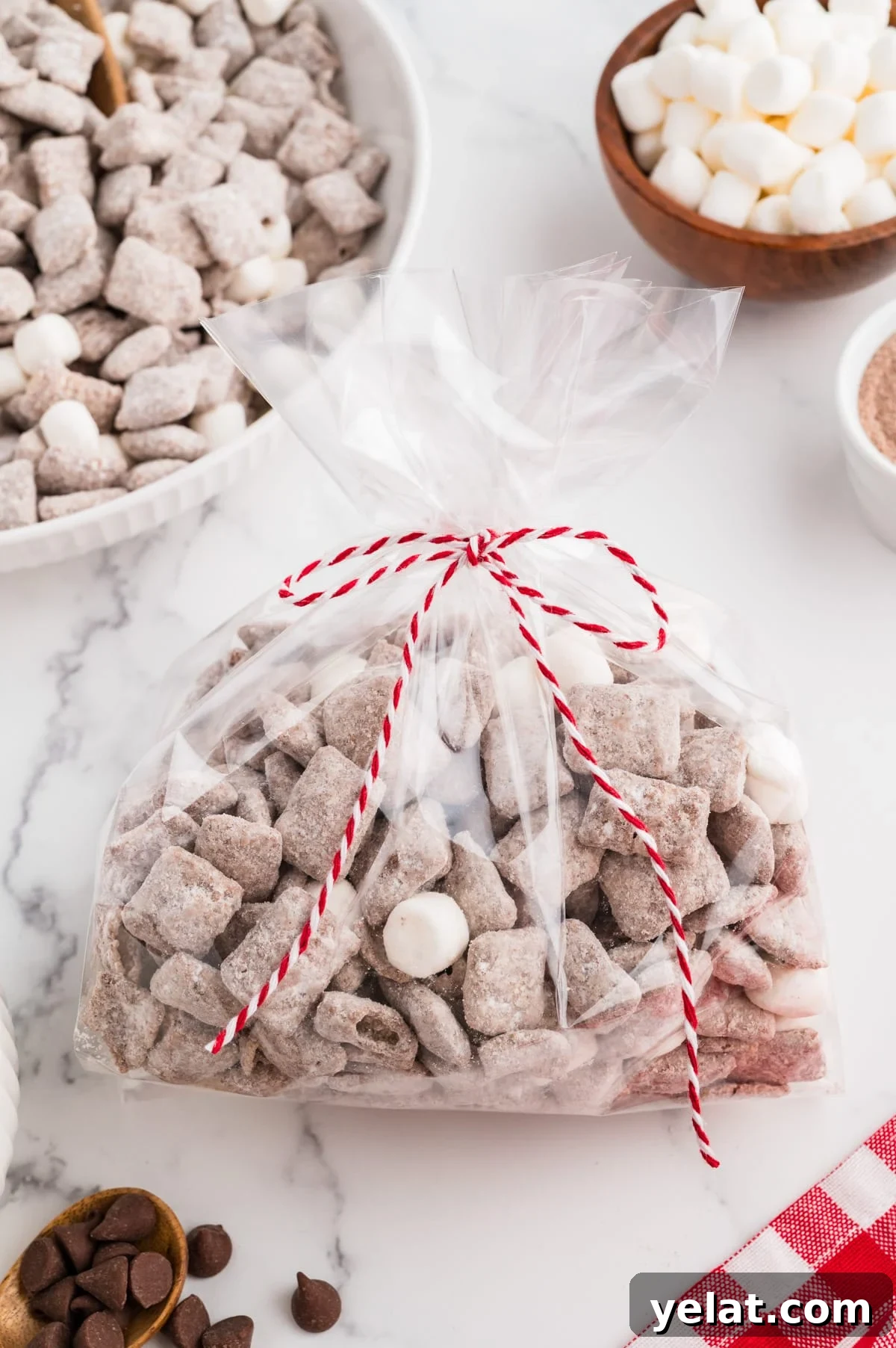 A cellophane gift bag filled with muddy buddies and tied with a decorative string.