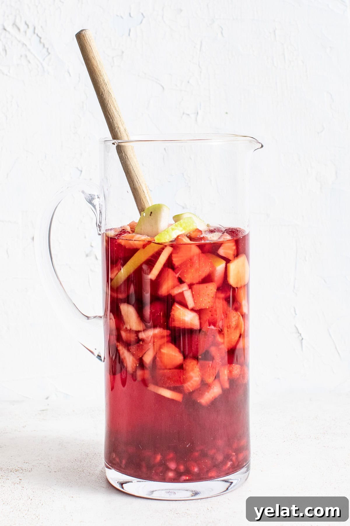 Pomegranate Virgin Sangria Recipe — Refreshing Party Drink 6 A pitcher of non-alcoholic sangria with fruit and ginger.