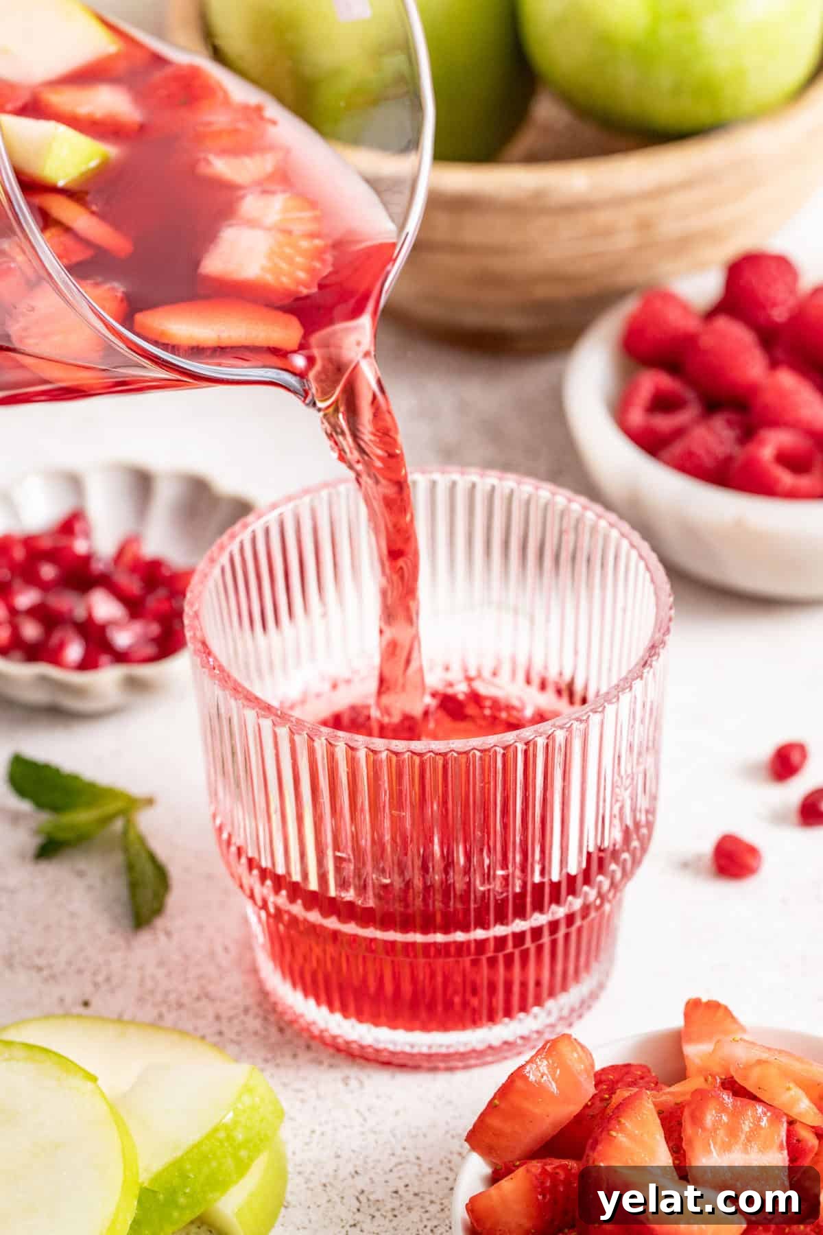 Pomegranate Virgin Sangria Recipe — Refreshing Party Drink 7 Pouring the pomegranate juice into a cup.