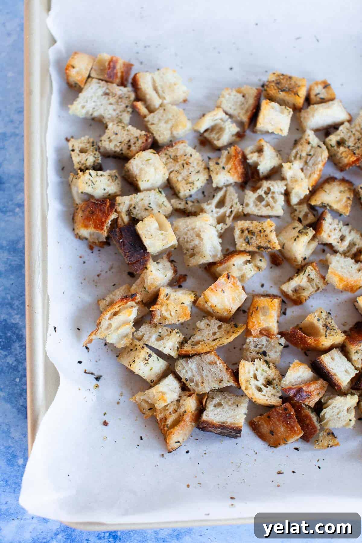 Crispy Homemade Croutons: Simple Recipe for Perfect Salads 2 Fully baked homemade croutons on the parchment-paper lined baking sheet.