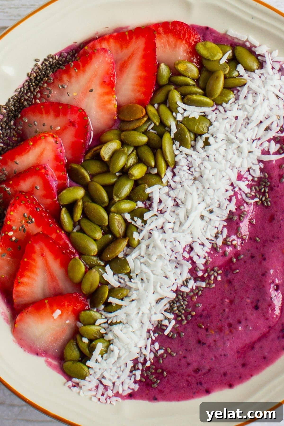 50 High-Protein Power Bowl Recipes for Every Meal 3 Berry protein smoothie bowl topped with sliced strawberries, pumpkin seeds, shredded coconut, and chia seeds