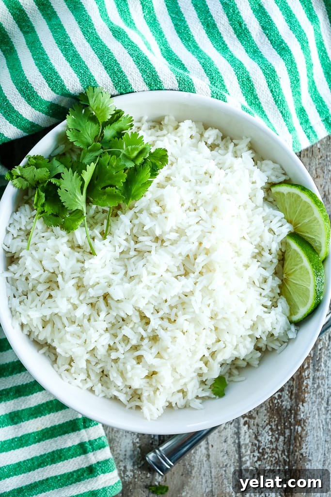 a white bowl of coconut rice recipe with cilantro and lime
