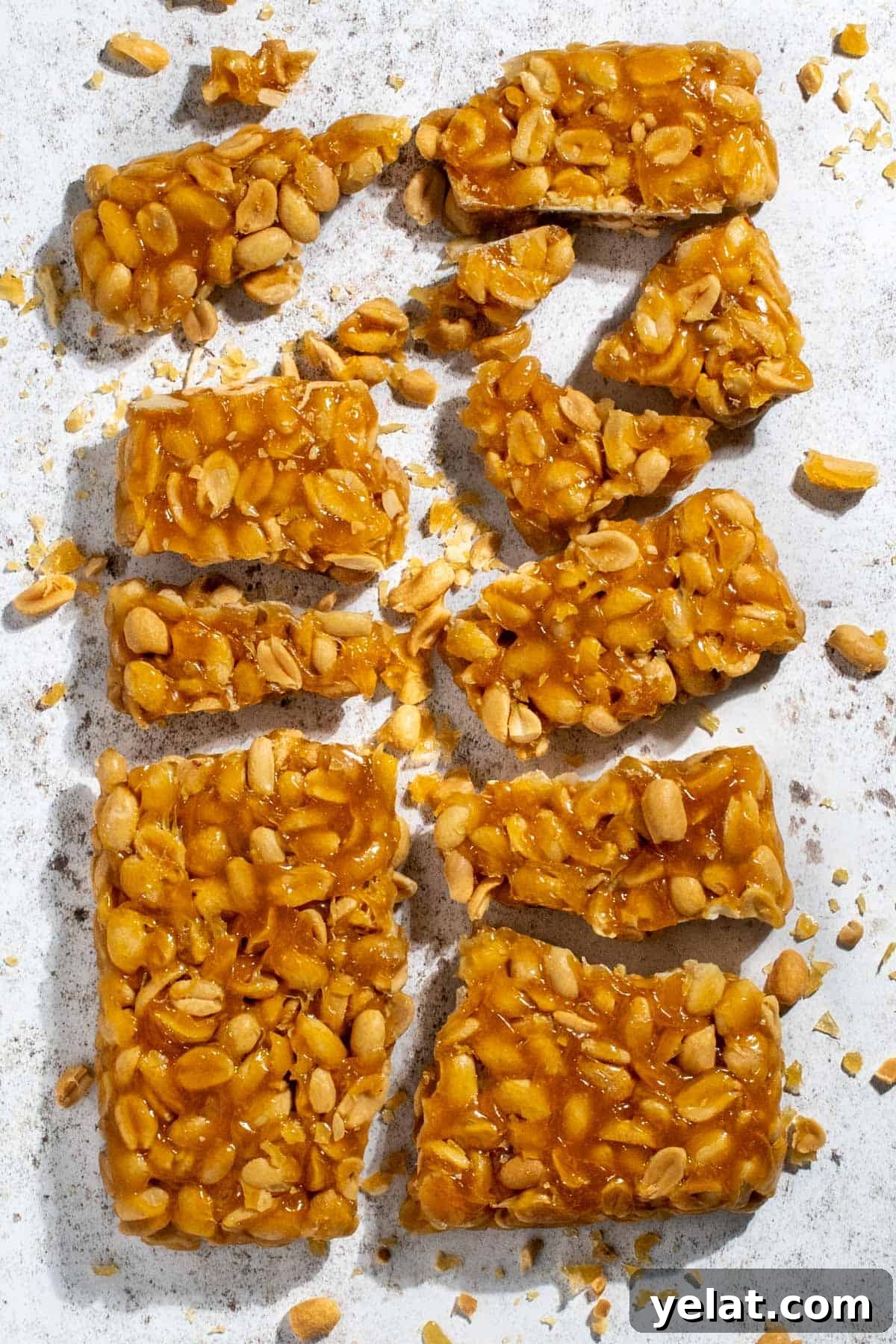 Homemade Peanut Brittle Without Corn Syrup — Crunchy Recipe 2 Peanut brittle without corn syrup broken into pieces on a white background.