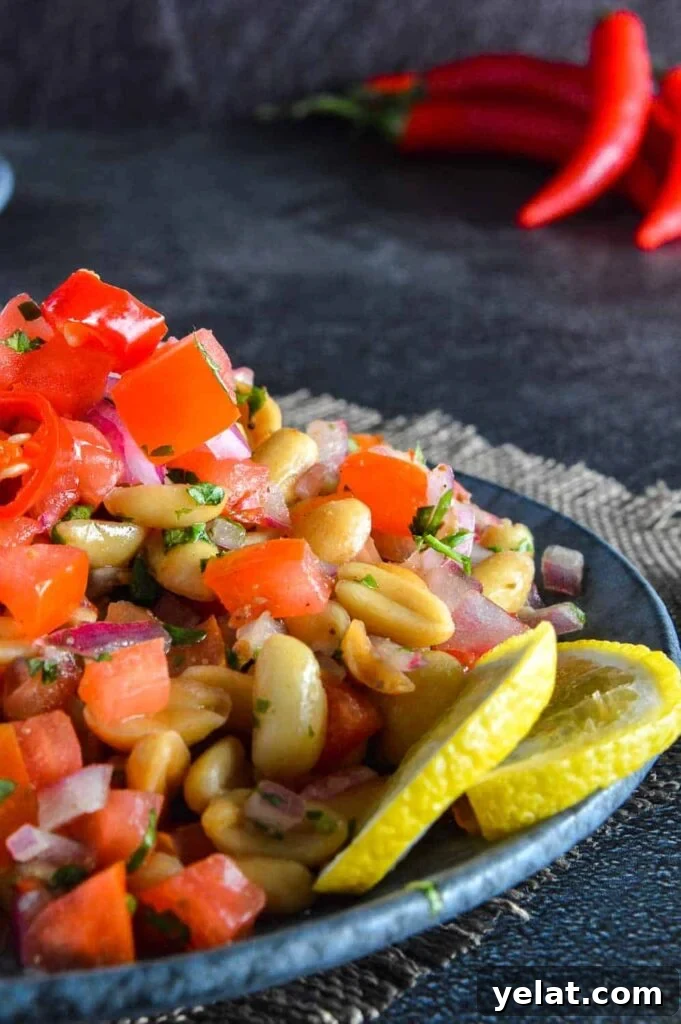 Spicy Peanut Chaat Recipe: Indian Masala Peanuts in Minutes 2 Close up of peanuts, coriander, lemon slices and tomatoes with red chili peppers in the background