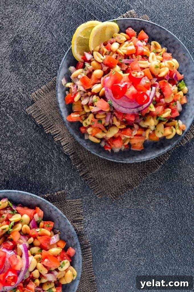 Spicy Peanut Chaat Recipe: Indian Masala Peanuts in Minutes 3 Two bowls of peanuts tomatoes and onions on a grey background