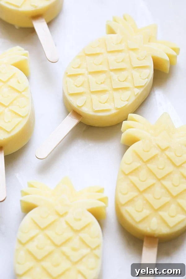 pineapple coconut rum  popsicles on a marble table.