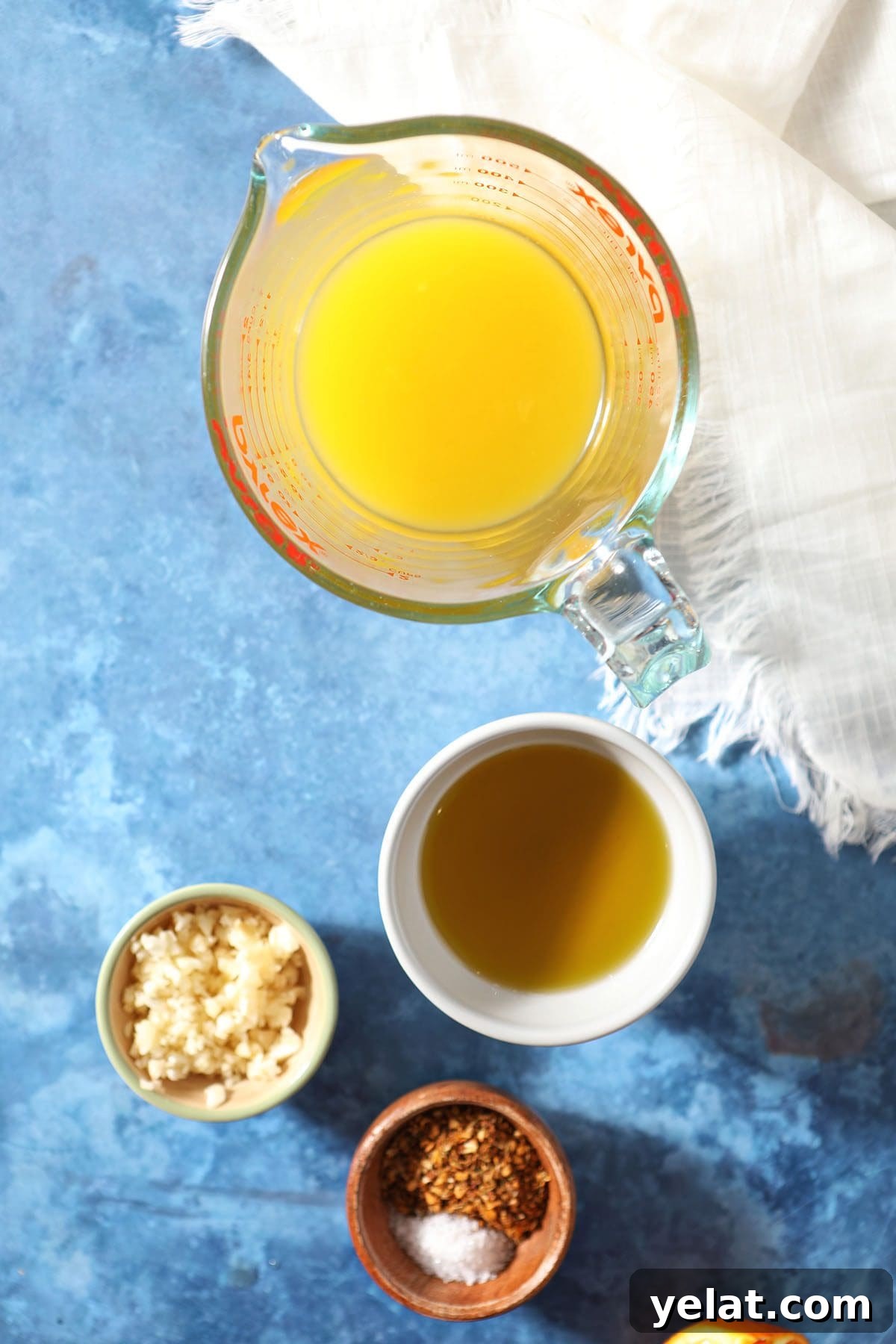 Citrus-Marinated Chicken Recipe for Juicy Flavor 3 Orange juice and other marinade ingredients in bowls on a blue countertop