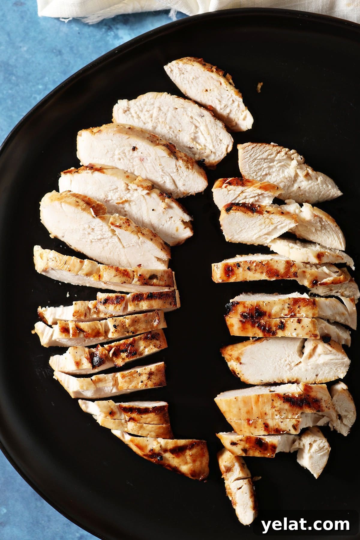 Citrus-Marinated Chicken Recipe for Juicy Flavor 6 Two sliced marinated and grilled chicken breasts on a black plate