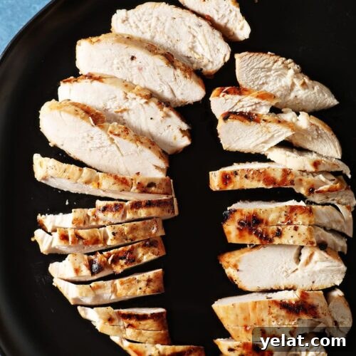 Citrus-Marinated Chicken Recipe for Juicy Flavor 7 Two sliced marinated and grilled chicken breasts on a black plate