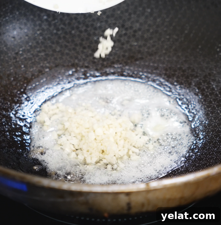 Garlic Butter Chicken Recipe with Crispy Pan-Seared Thighs 6 Minced garlic sizzles in melted butter inside a nonstick pan, releasing its aroma for the garlic butter sauce.