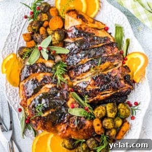 Glazed Turkey Breast in an Air Fryer: Juicy, Quick Recipe 13 square image of air fryer glazed turkey breast on a plater with herbs, orange slices, and roasted veggies