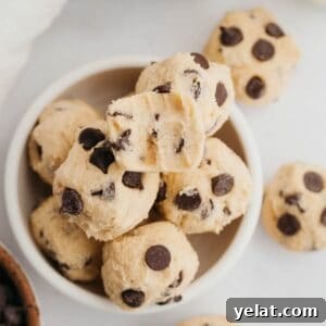 No-Bake Chocolate Chip Cookie Dough Bites for Snacking 11 no bake chocolate chip cookie dough bites in a small ceramic bowl.