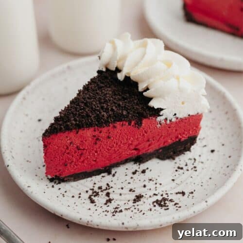 A slice of red velvet oreo cheesecake on a small white plate.
