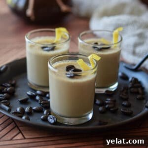 Espresso panna cotta in small glass jars topped with coffee beans and lemon rind.