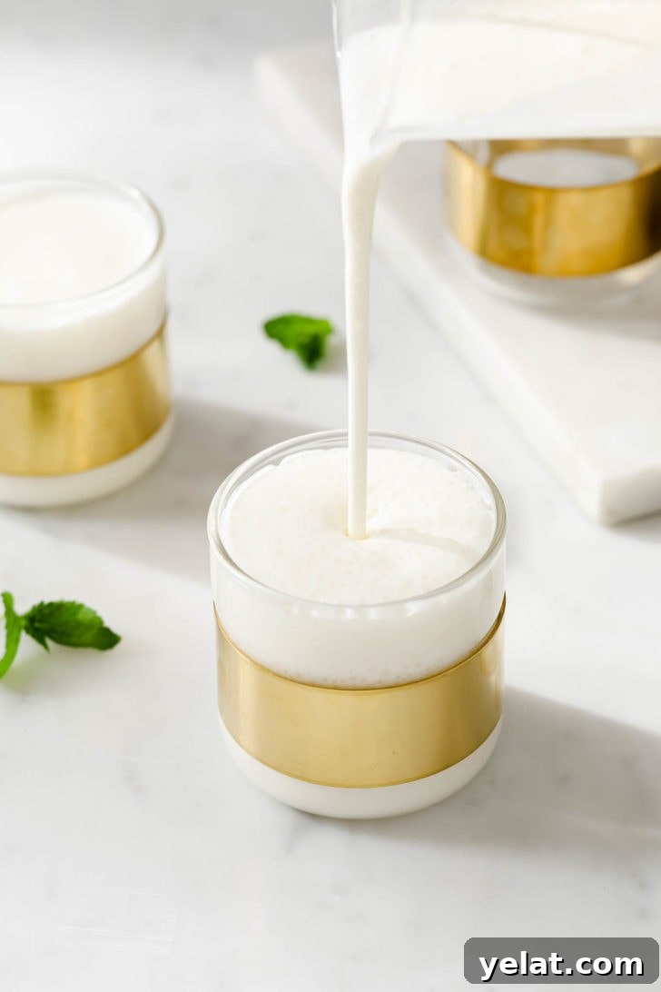 Authentic Sweet Lassi Recipe: Creamy Indian Yogurt Drink Guide 2 Pouring frothy sweet lassi into a glass.