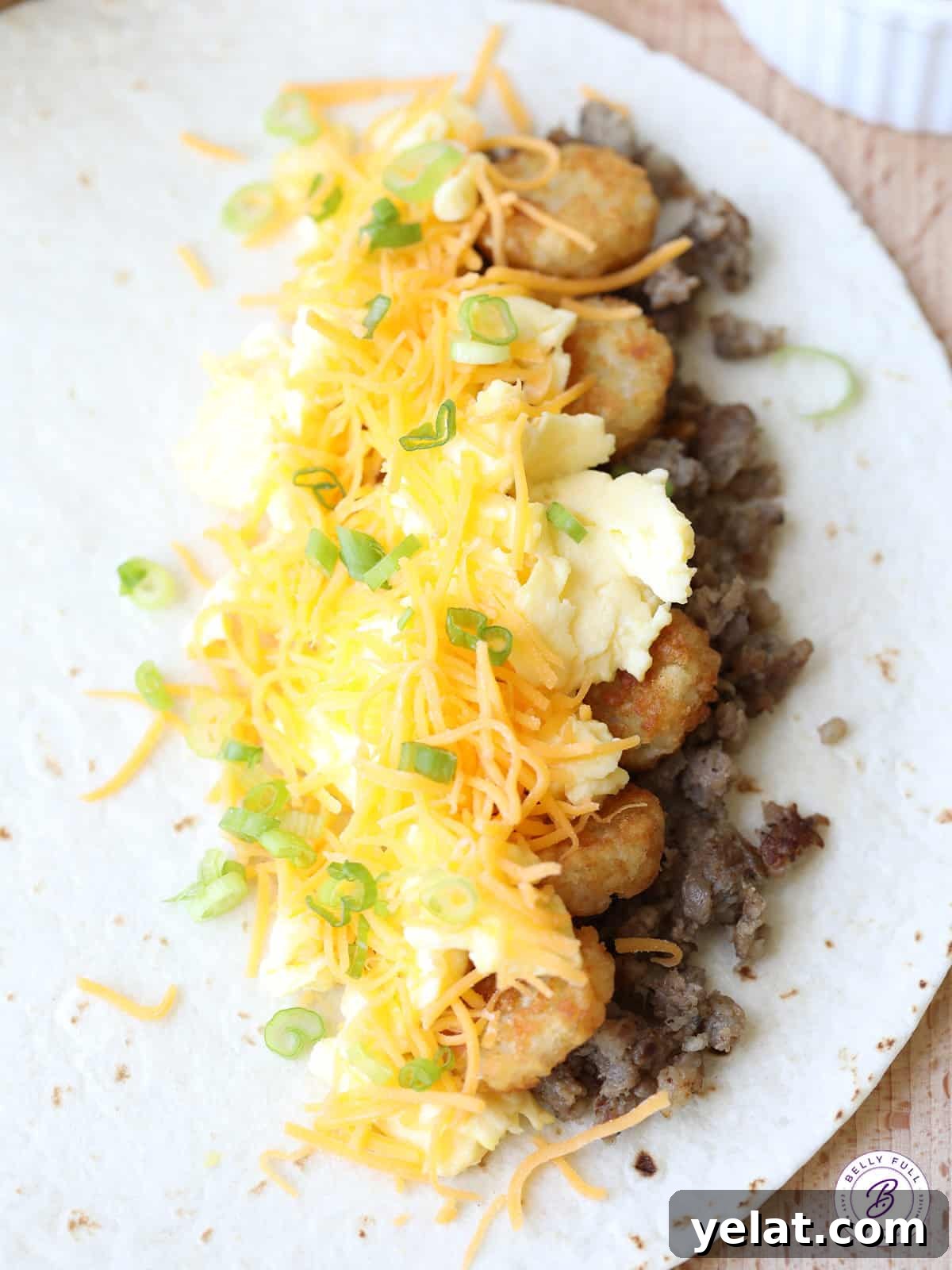 flour tortilla with sausage, tater tots, eggs, and cheese