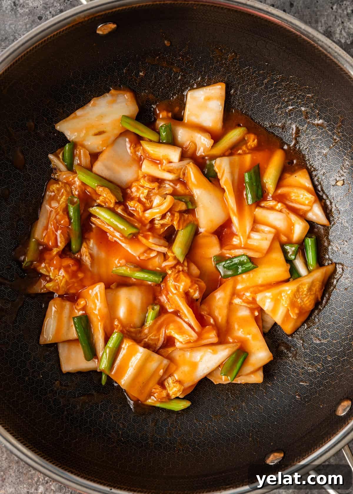 overhead process shot: cooking cabbage stir fry in a wok