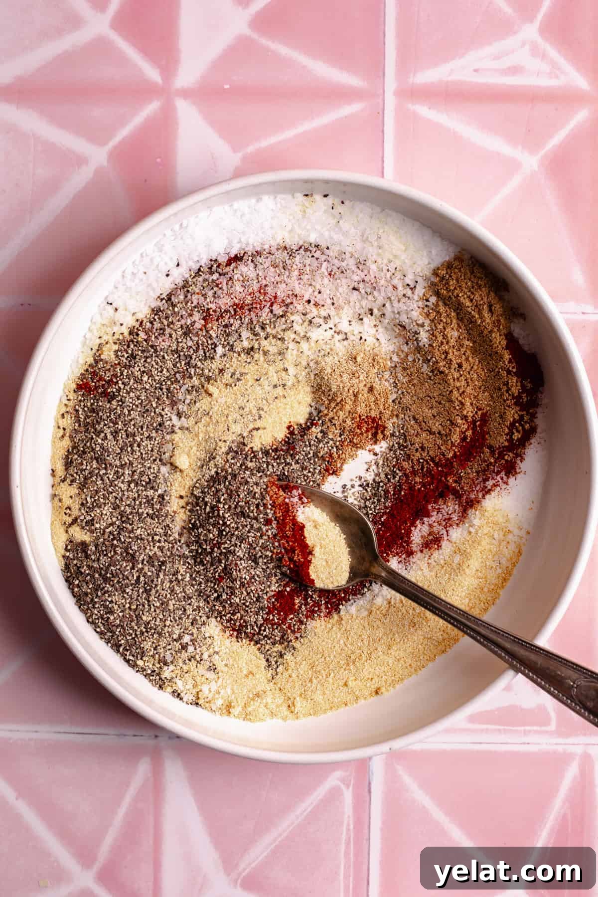 Ultimate Texas-Style Brisket Rub Recipe for Smoky Flavor 5 Plate with seasoning mix for a brisket rub and a spoon.