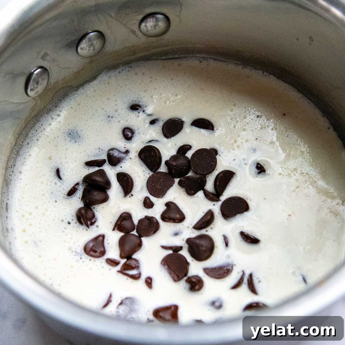 Ultra-Cream Gluten-Free Oreo Cheesecake Recipe 7 chocolate chips being melted in heavy cream
