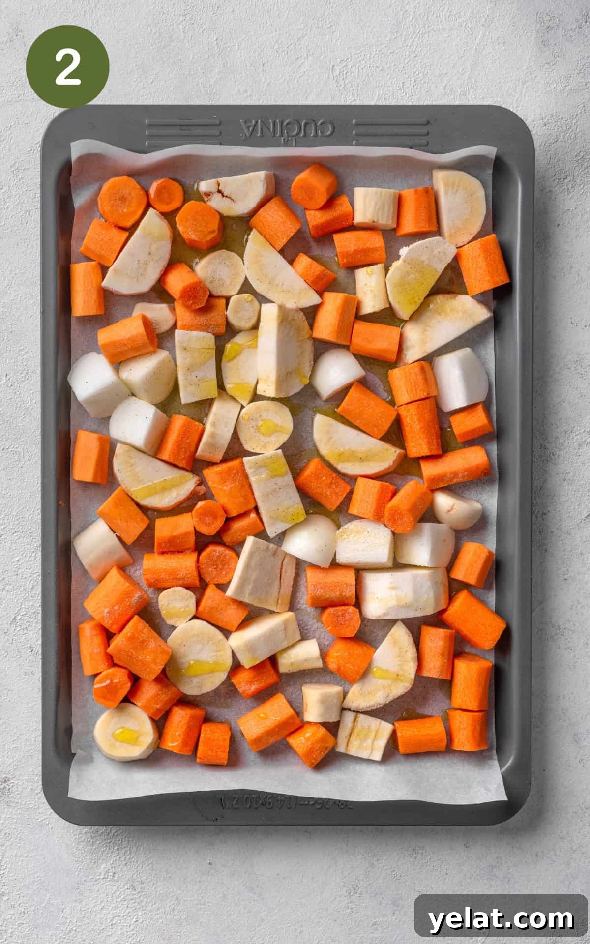 Creamy Carrot and Parsnip Soup Recipe for Cozy Meals 5 carrots, parsnip, and garlic on a baking tray.