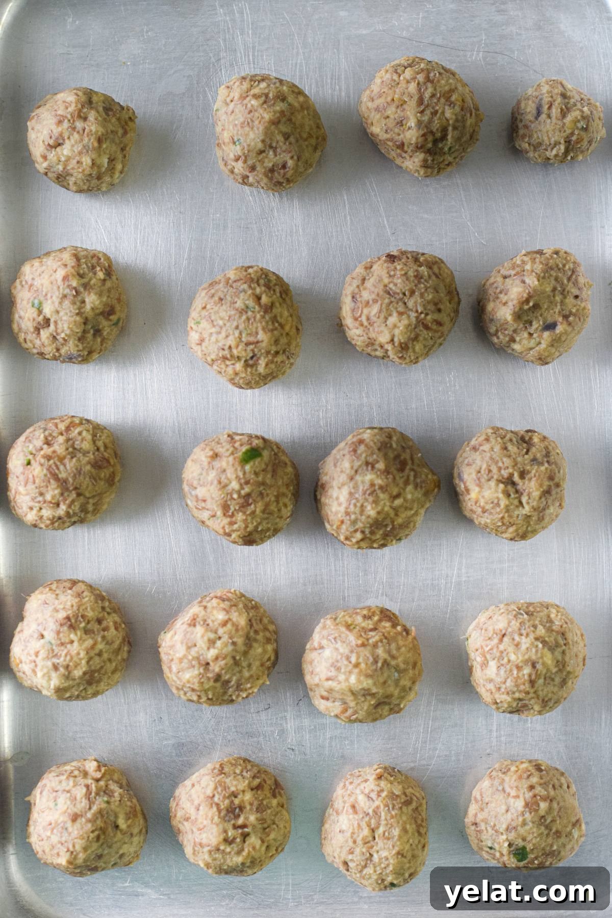 Air Fryer Meatballs in Marinara Sauce: Quick Homemade Recipe 16 Unbaked easy vegan meatballs arranged in neat rows on a metal baking sheet, ready to be cooked and enjoyed with spaghetti marinara.