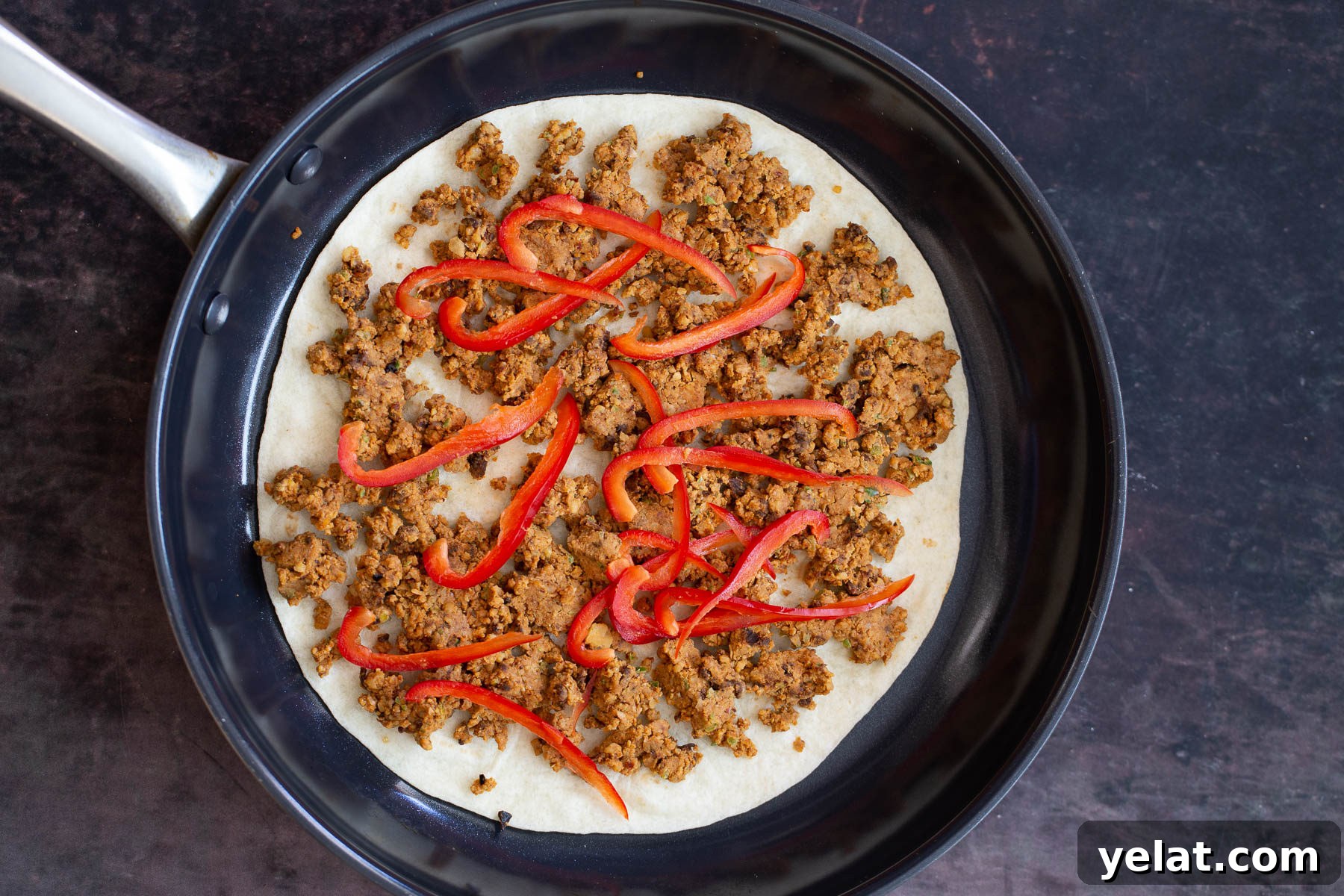 walnut taco meat vegan walnut taco meat quesadilla being assembled in black skillet