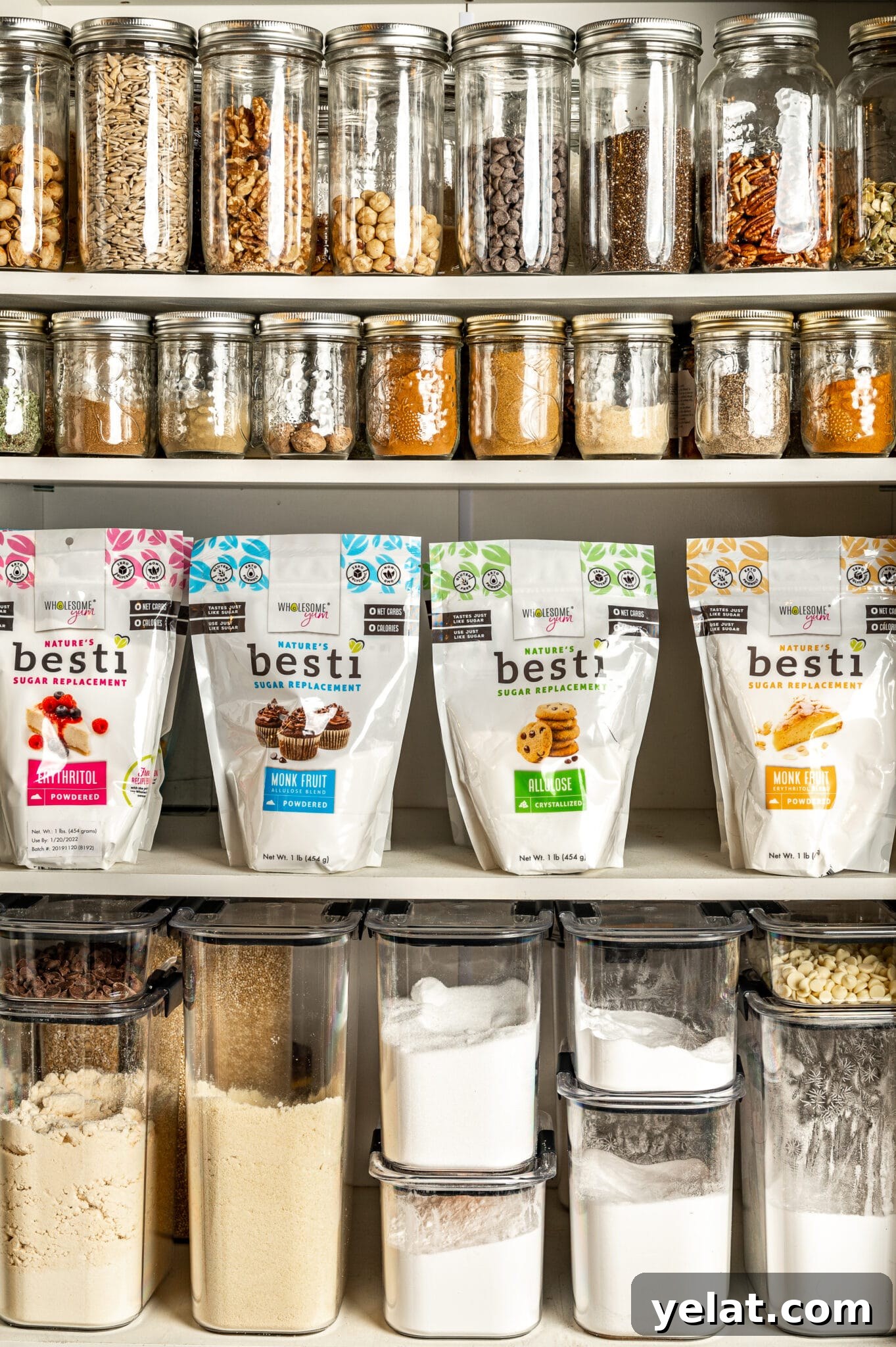 Low-Carb Pantry Essentials for Baking: Flour Substitutes & Staples 2 low carb baking essentials pantry with glass jars filled with nuts, seeds and spices and bags of low carb sweeteners and canisters of low carb flours.