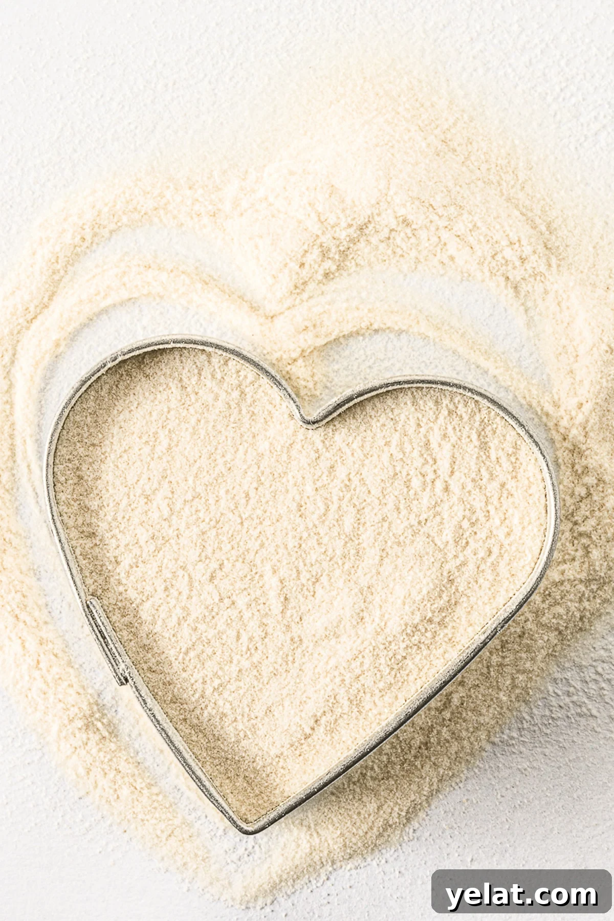 Low-Carb Pantry Essentials for Baking: Flour Substitutes & Staples 14 Xanthan gum spread on a bright white table with a silver heart cookie cutter.