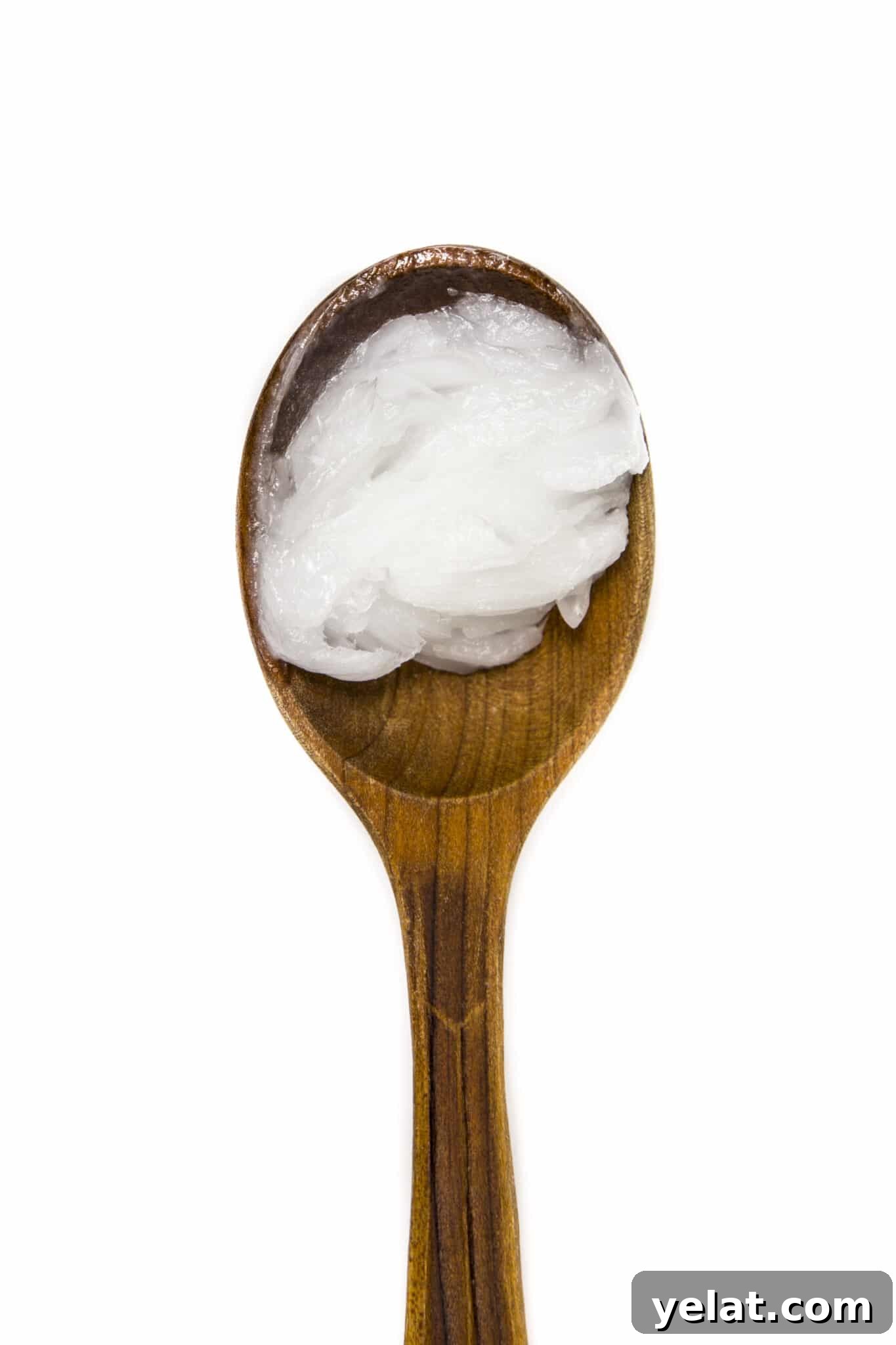 Low-Carb Pantry Essentials for Baking: Flour Substitutes & Staples 17 Coconut on a wooden spoon against an isolated white background.