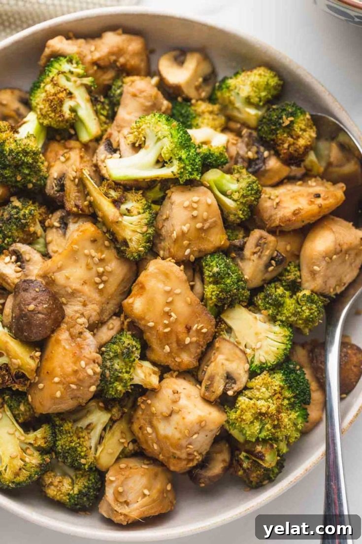 Serving bowl with chicken and broccoli and a serving spoon.