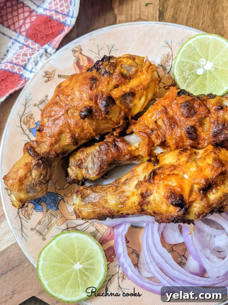 Air fried chicken legs plated with lime and red onion.