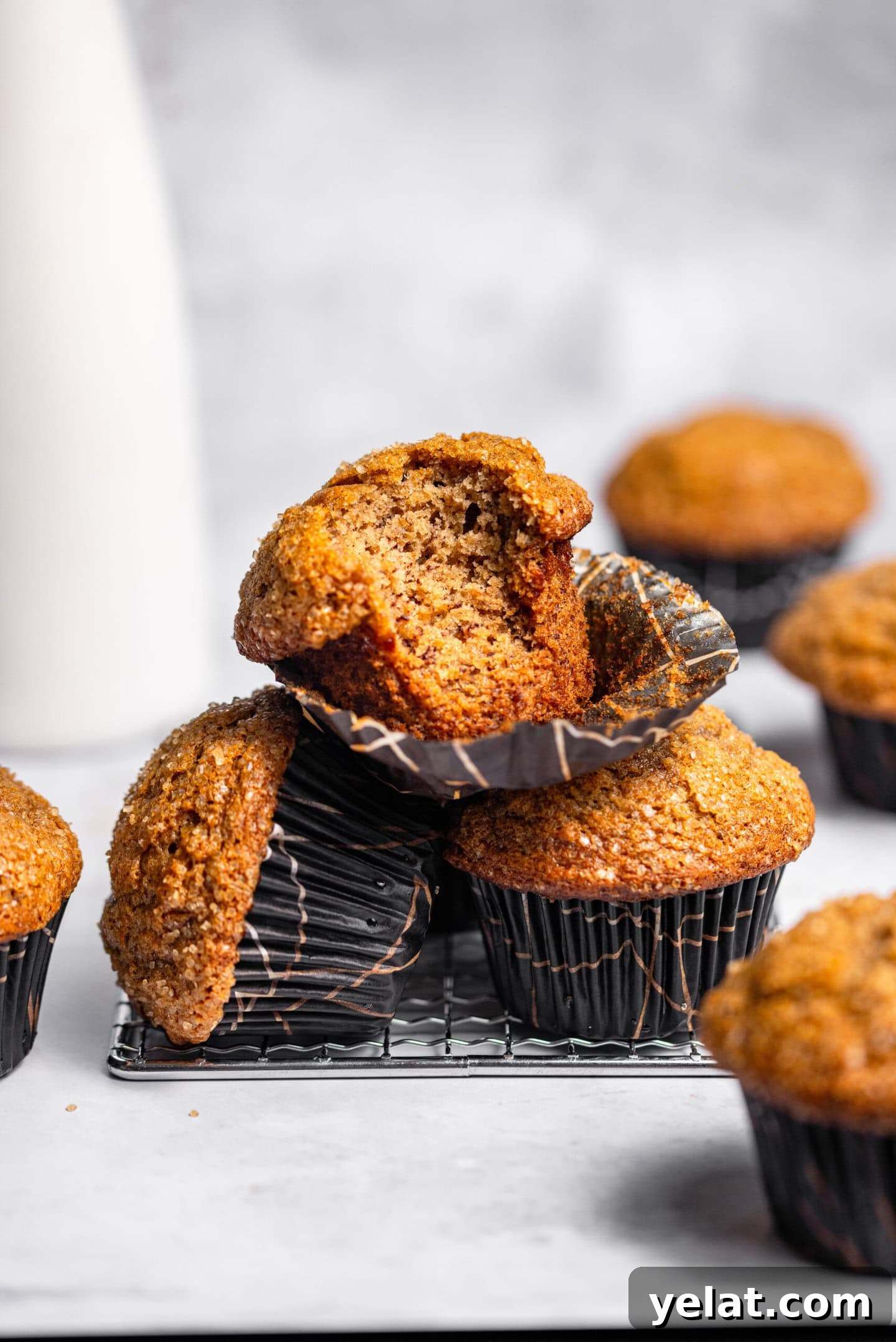 Moist Small-Batch Banana Muffins Recipe for Perfect Breakfast 12 A stack of banana muffins with a bite missing from the top one.
