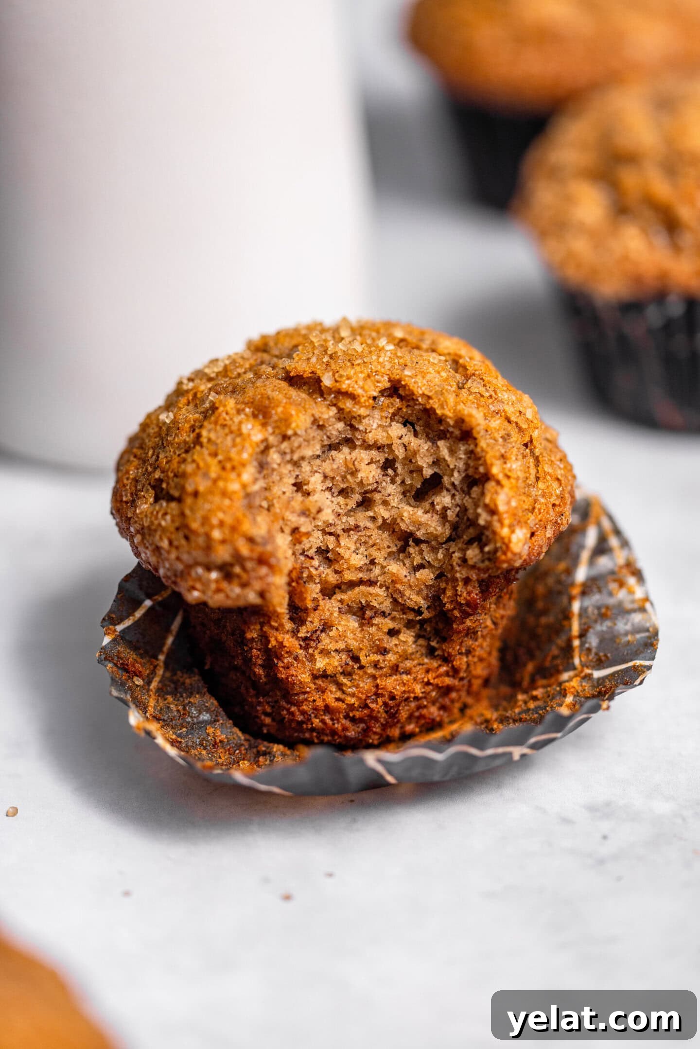 Moist Small-Batch Banana Muffins Recipe for Perfect Breakfast 3 Close up of banana muffin with a bite missing showing moist and tender crumb interior