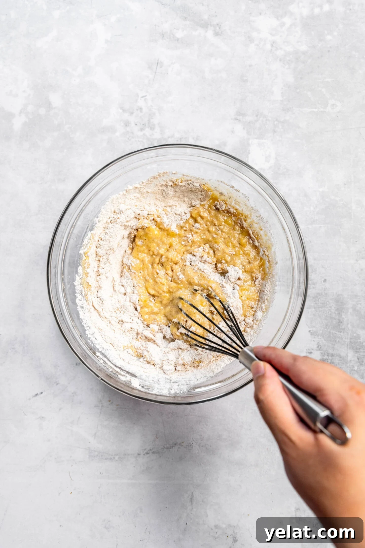 Moist Small-Batch Banana Muffins Recipe for Perfect Breakfast 8 Dry ingredients being whisked into the wet ingredients