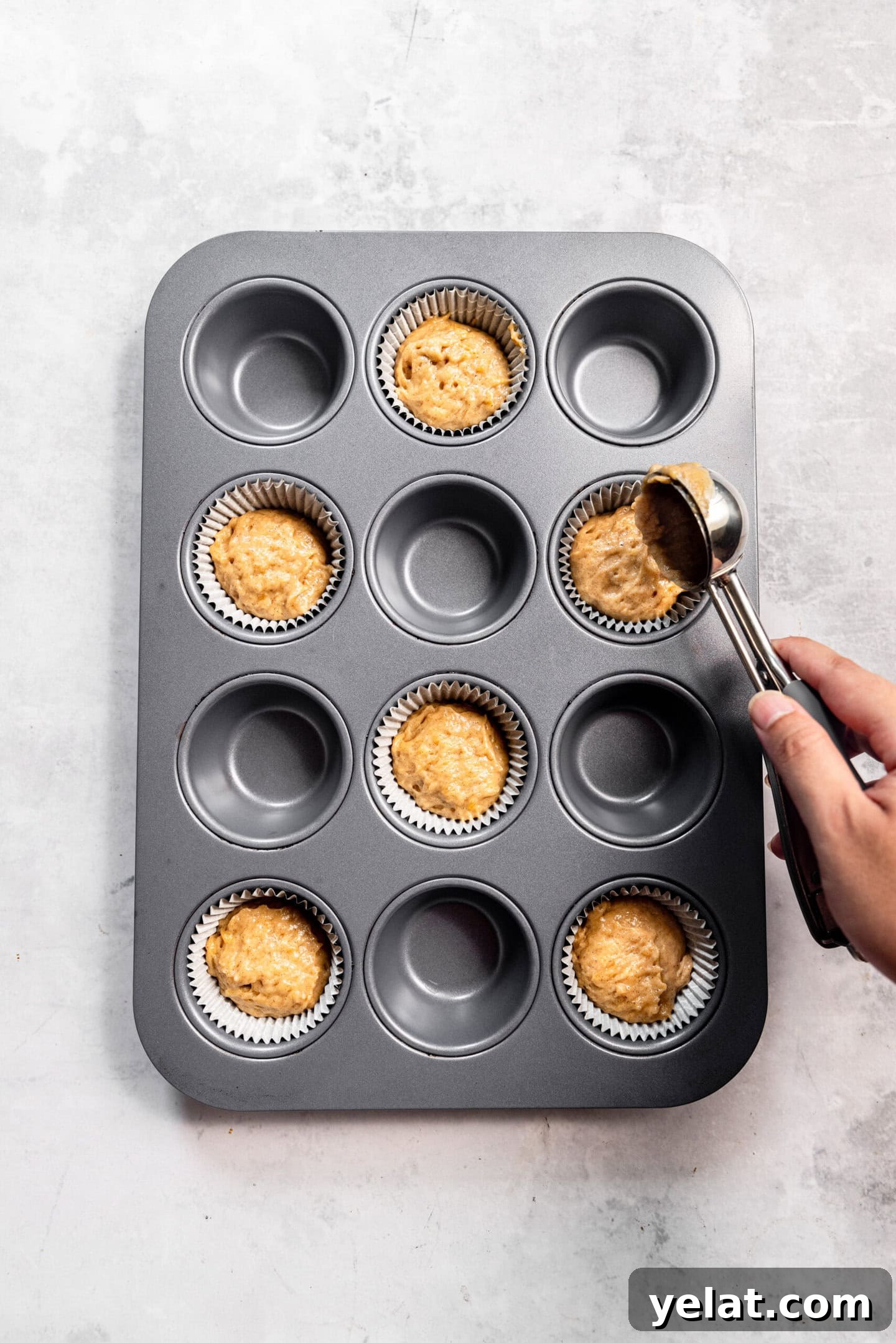 Moist Small-Batch Banana Muffins Recipe for Perfect Breakfast 9 Muffin batter being scooped into a prepared muffin pan