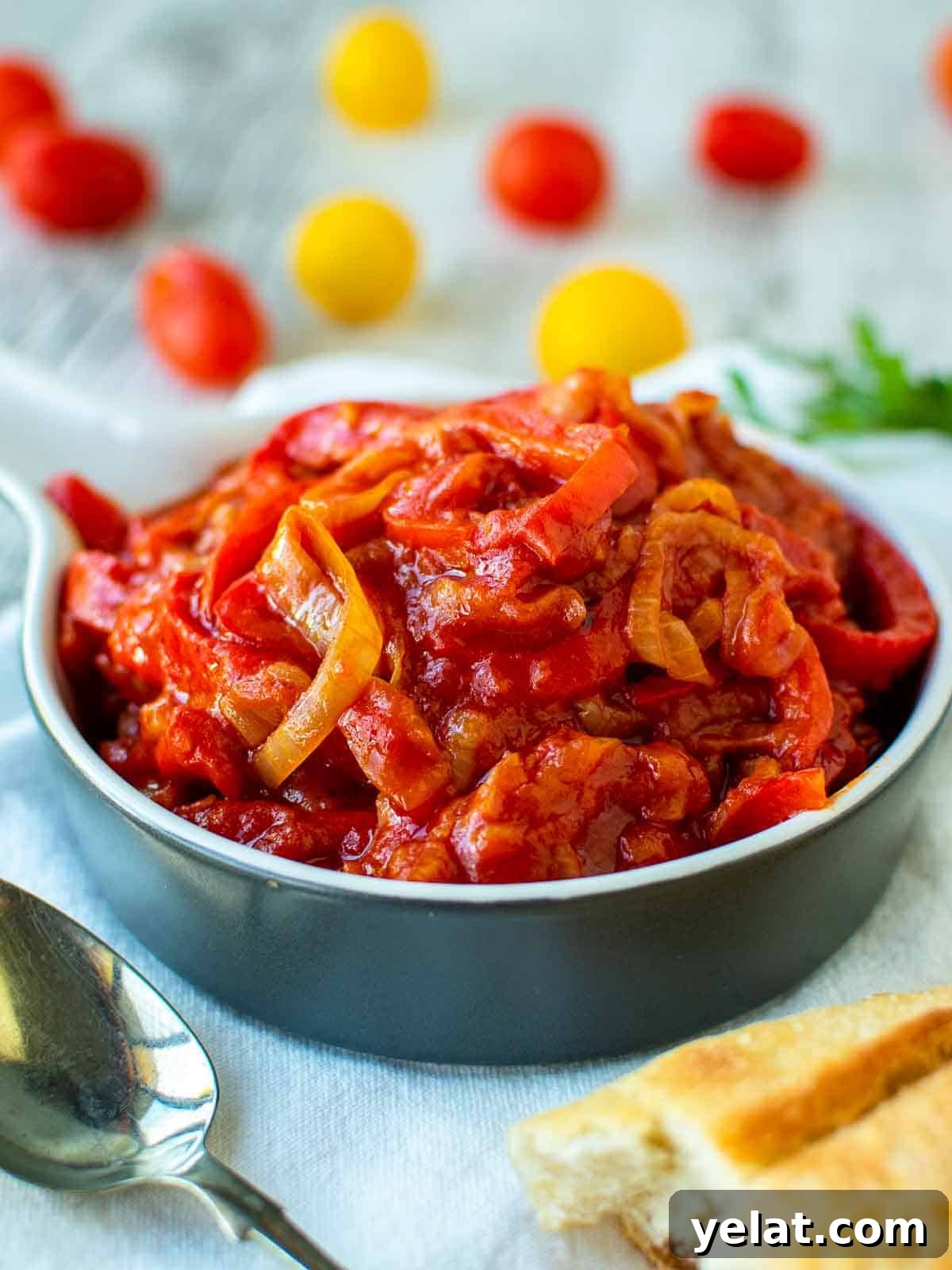 Authentic Italian Peperonata Recipe – Sweet Pepper Stew 2 Stewed peperonata using bell pepper and tomatoes in blue bowl.