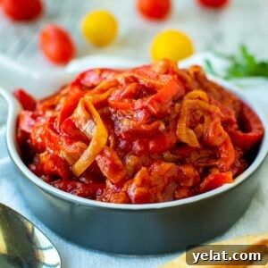 Authentic Italian Peperonata Recipe – Sweet Pepper Stew 7 Stewed bell pepper and tomatoes in blue bowl.